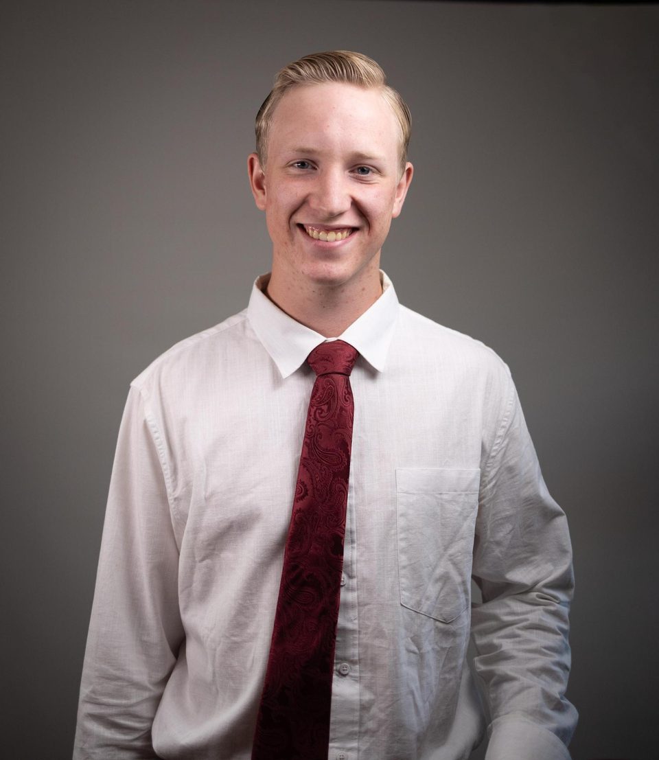 Christopher Moore smiling, in a white shirt and red tie